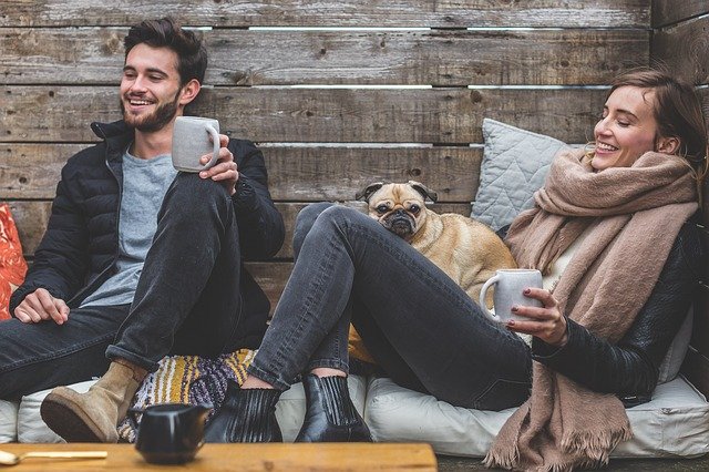 犬とコーヒーを楽しむカップル