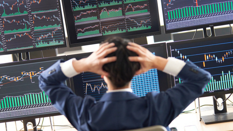 株チャートを見て頭を抱える男性