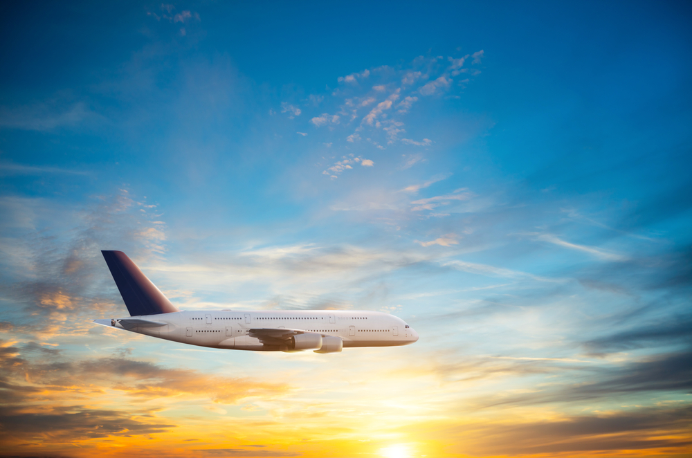 夕暮れの空を飛ぶ飛行機