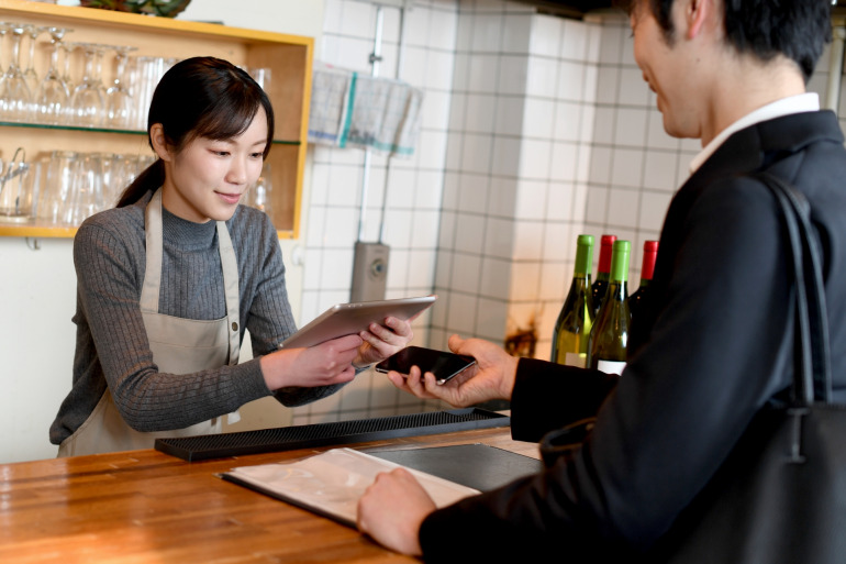 カフェのレジでキャッシュレス決済している様子