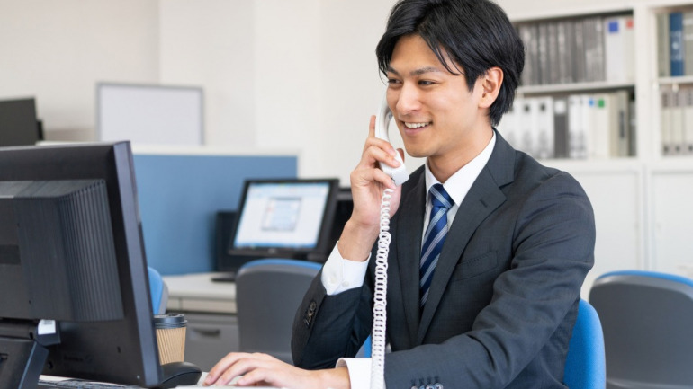 会社で電話をかける男性