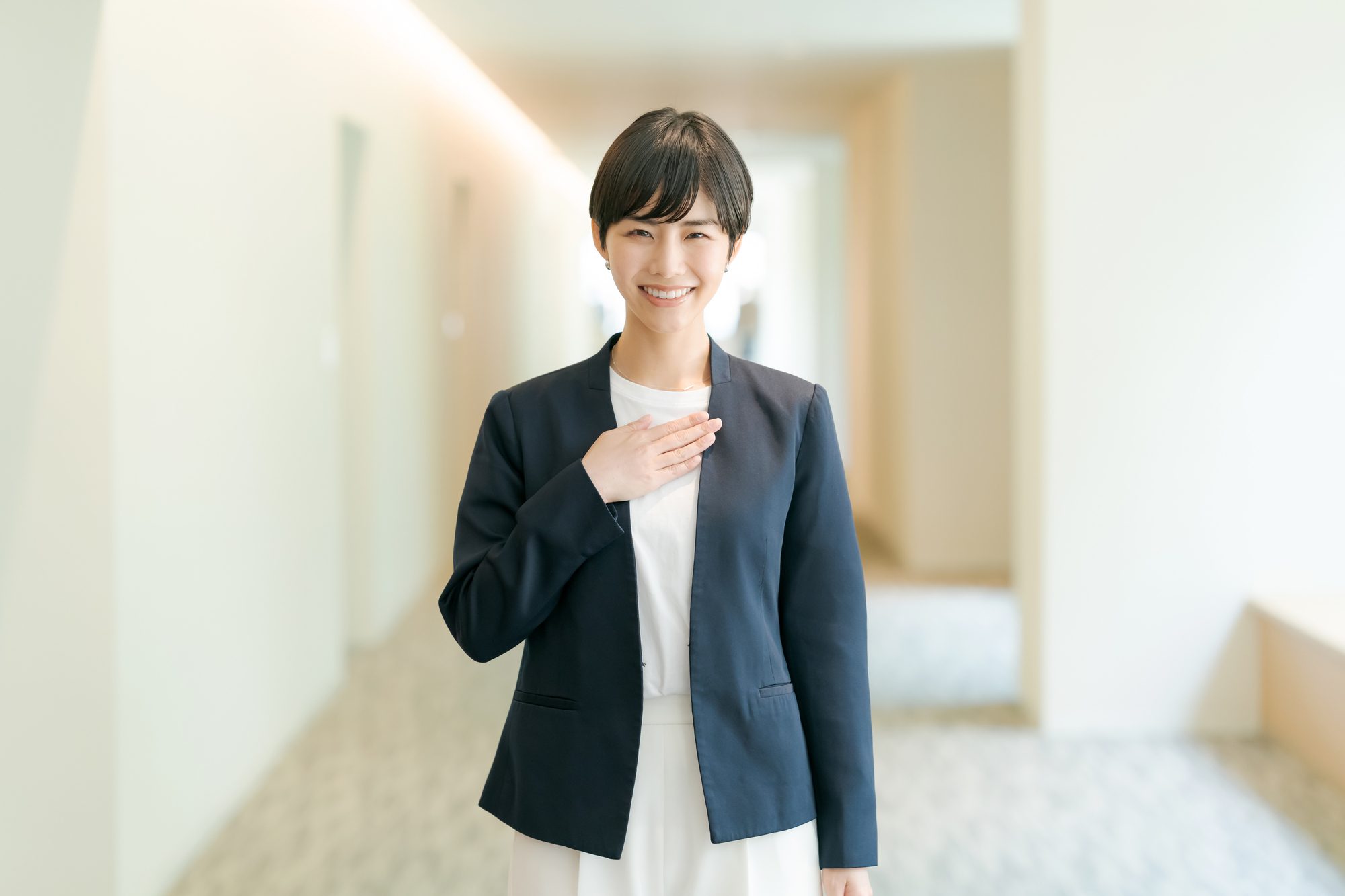 胸に手を当てるスーツの人物
