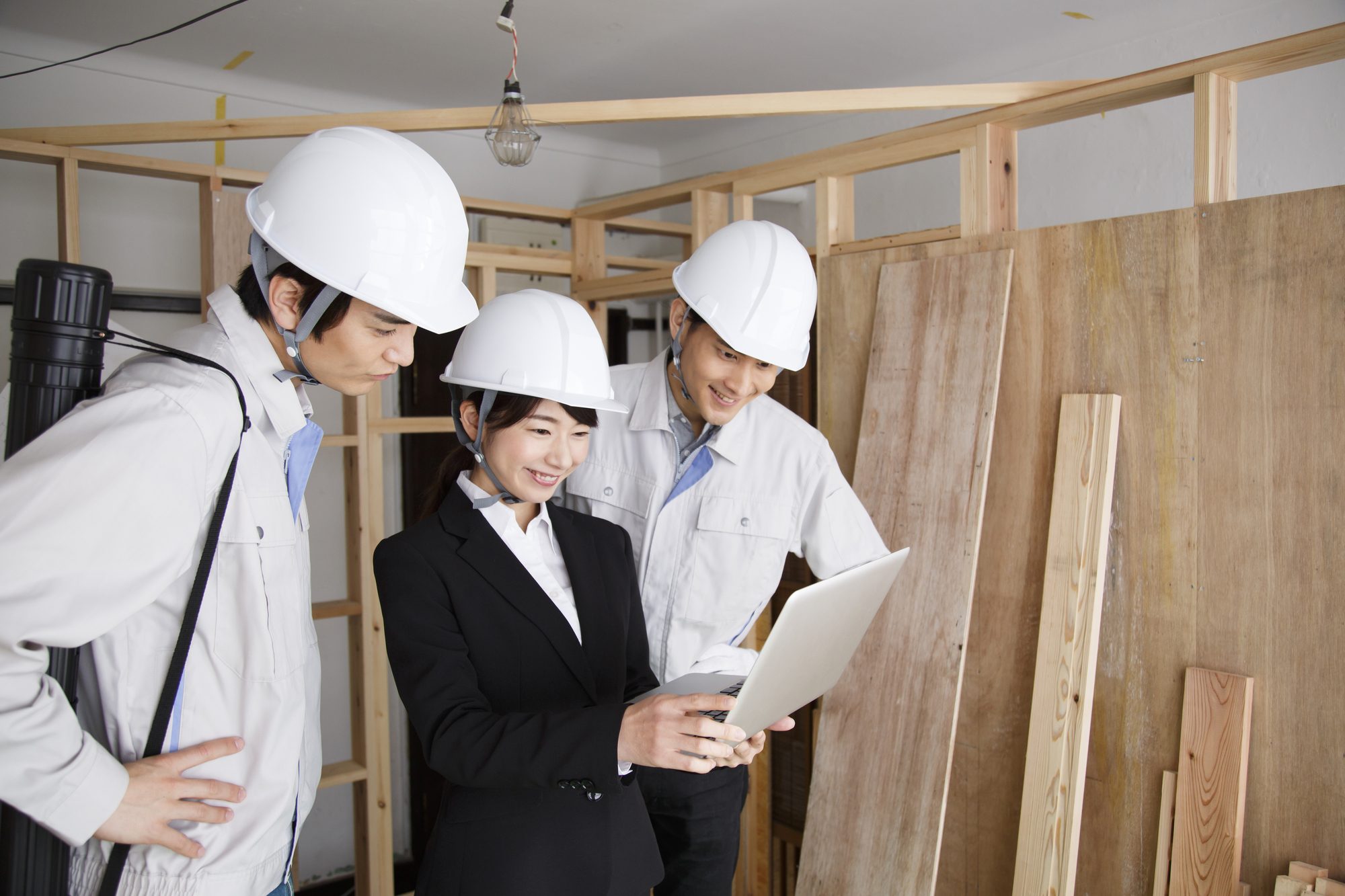 建築現場の設計図を見るスタッフ