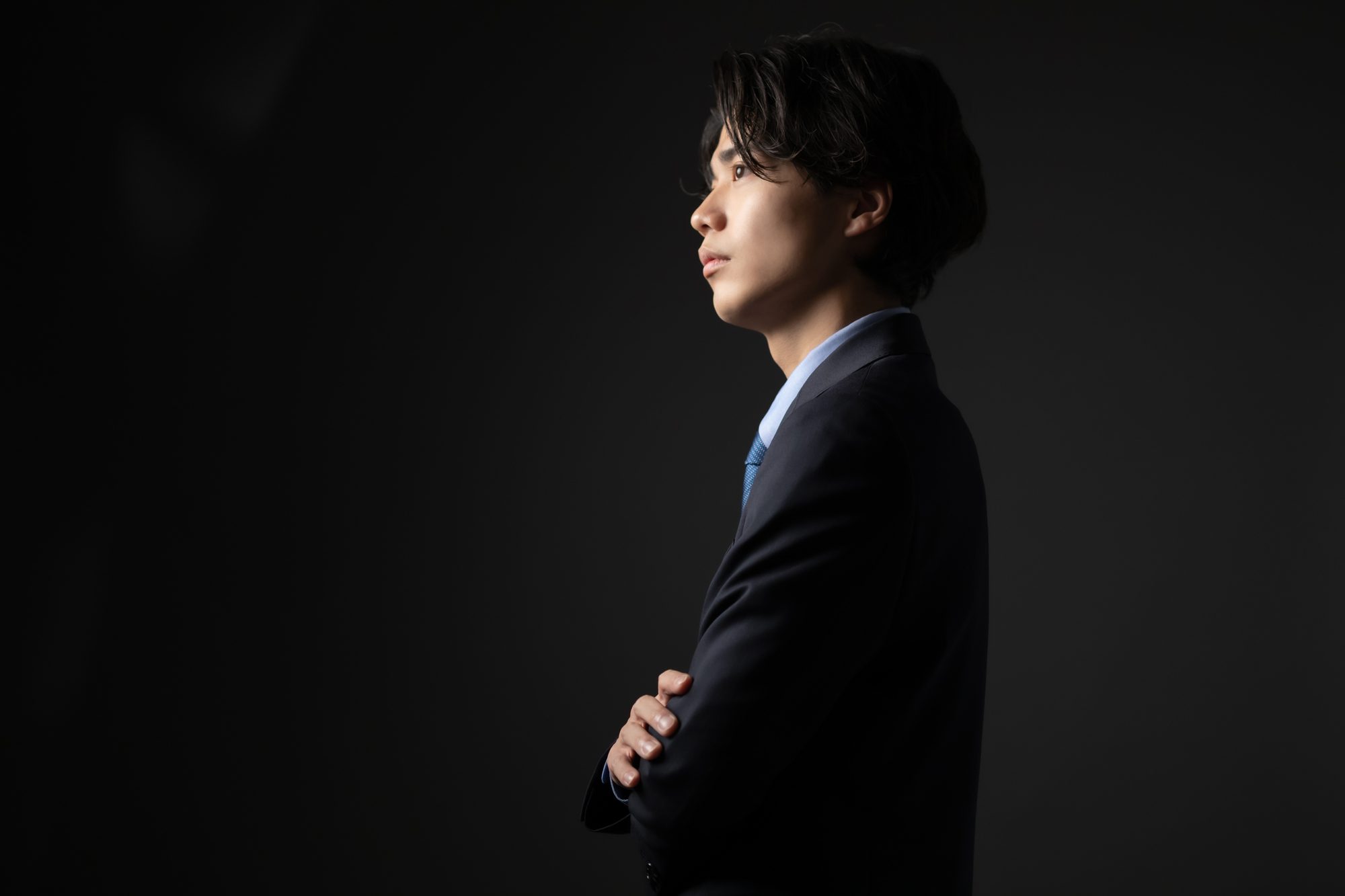 腕組みをするスーツの人物