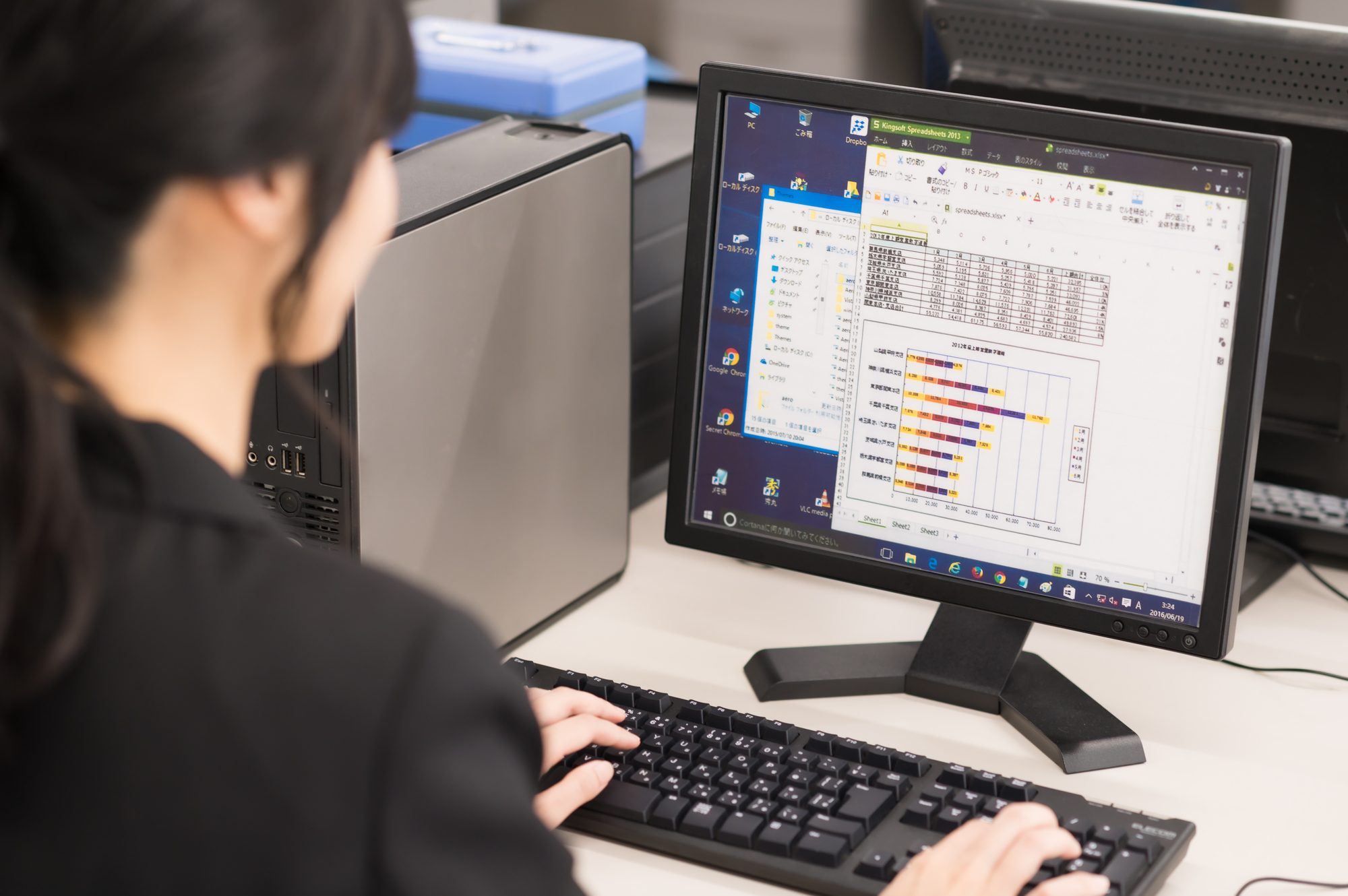 スプレッドシートで作業をする人物
