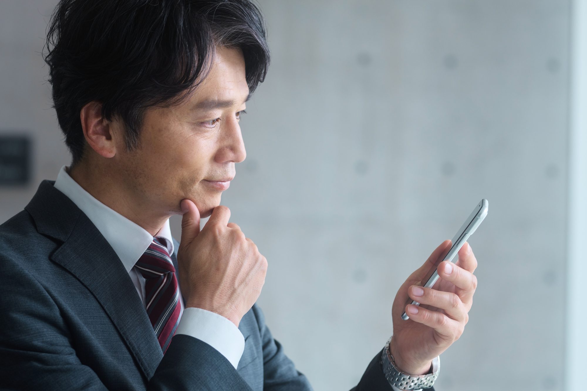 スマホを眺めるビジネスパーソン