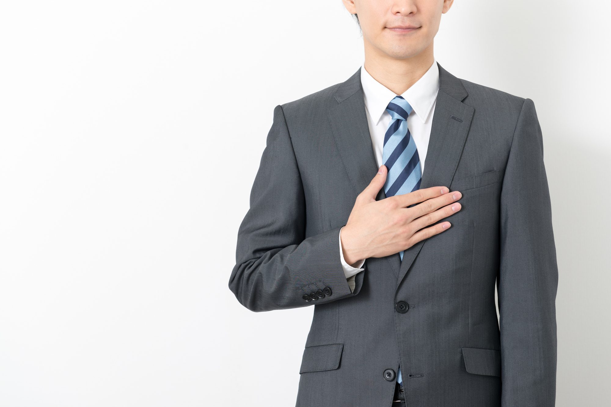 胸に手を当てるスーツの人物