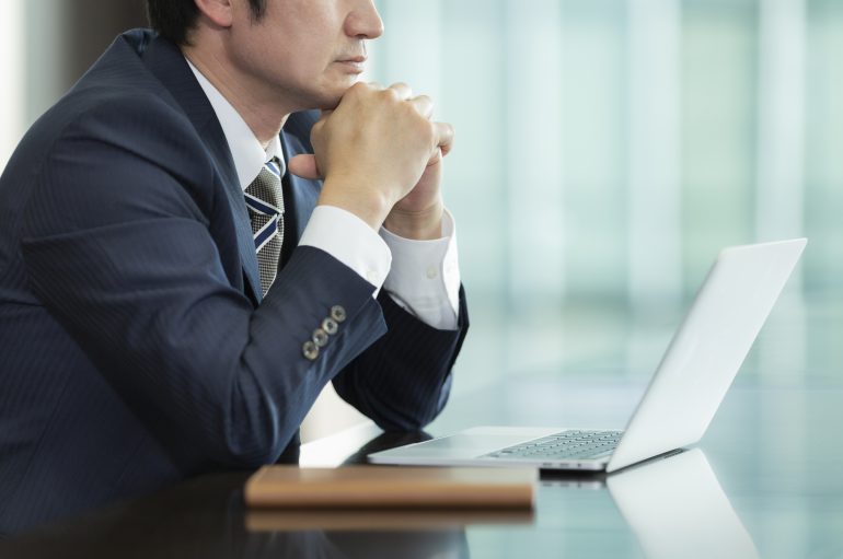 考え事をするビジネスパーソン
