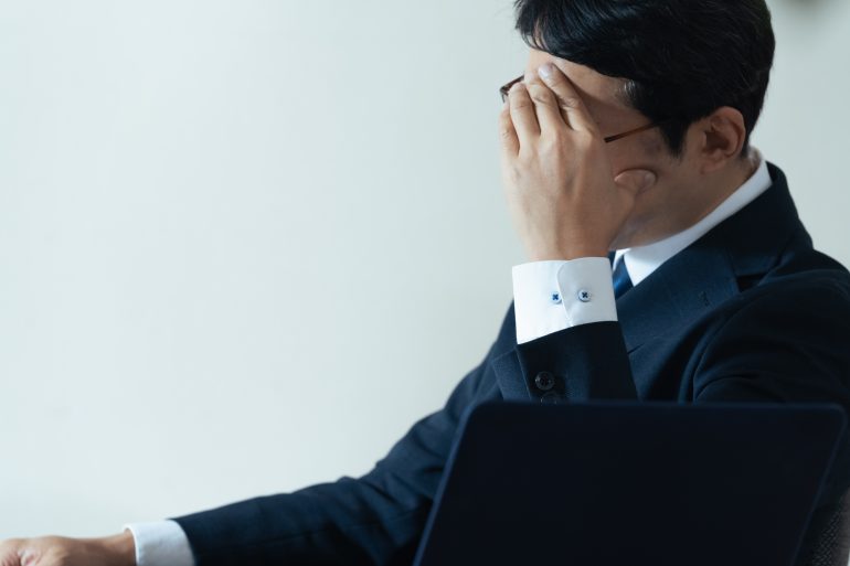 頭を抱えるビジネスパーソン