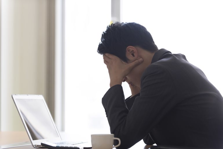 頭を抱えるビジネスパーソン