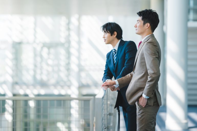 遠くを見る２人のビジネスパーソン