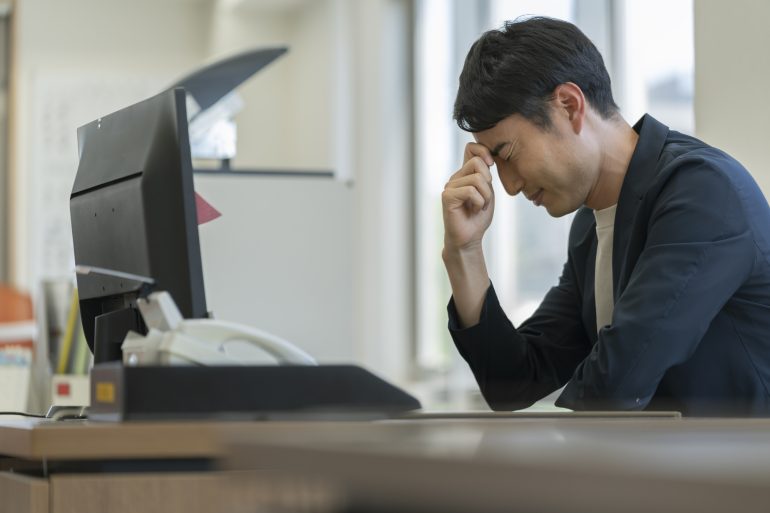 頭を抱えるビジネスパーソン